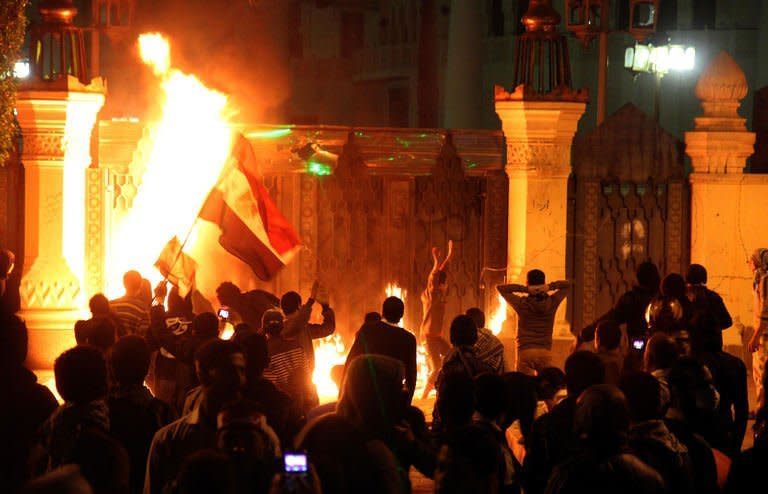 Egyptian anti-regime protesters set fire to the gate of the presidential palace during a demonstration in Cairo on February 8, 2013. Police fired volleys of tear gas at protesters in several provinces, as thousands took to the streets to demand Islamist President Mohamed Morsi fulfil the goals of the revolt that brought him to power