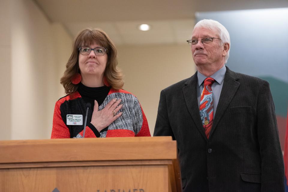 Larimer County Clerk and Recorder Angela Myers is joined by her husband, Gary Myers, at the podium during a swearing-in ceremony for newly elected county officials Tuesday in Fort Collins.