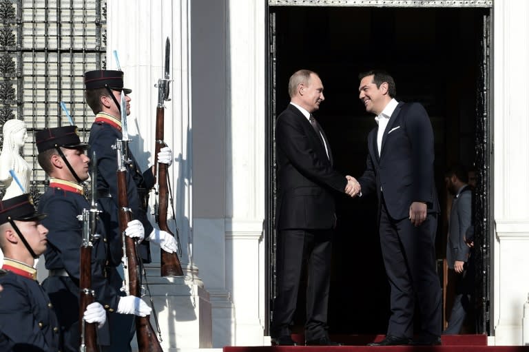 Greek Prime Minister Alexis Tsipras (R) shakes hands with Russia's President Vladimir Putin before their meeting in Athens on May 27, 2016