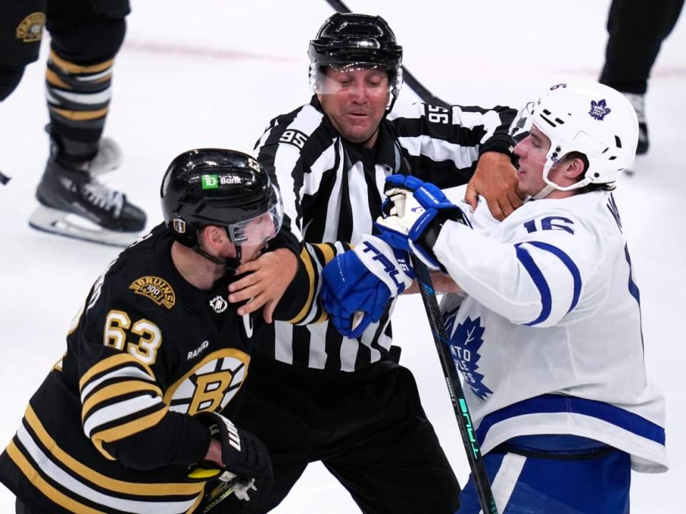 NHL linesman Jonny Murray tries to separate Brad Marchand and Mitch Marner during Game 5 of the NHL playoff series between the Bruins and the Leafs Tuesday in Boston. Cable TV's last line of defence against cord cutting has long been the audience for live sports, but a bid by streaming companies to air sports on their platforms could change that. (Charles Krupa/Associated Press - image credit)