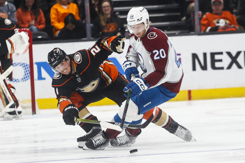 Anaheim Ducks forward Isac Lundestrom, left, and Colorado Avalanche forward Lars Eller vie for the puck during the second period of an NHL hockey game in Anaheim, Calif., Monday, March 27, 2023. (AP Photo/Ringo H.W. Chiu)