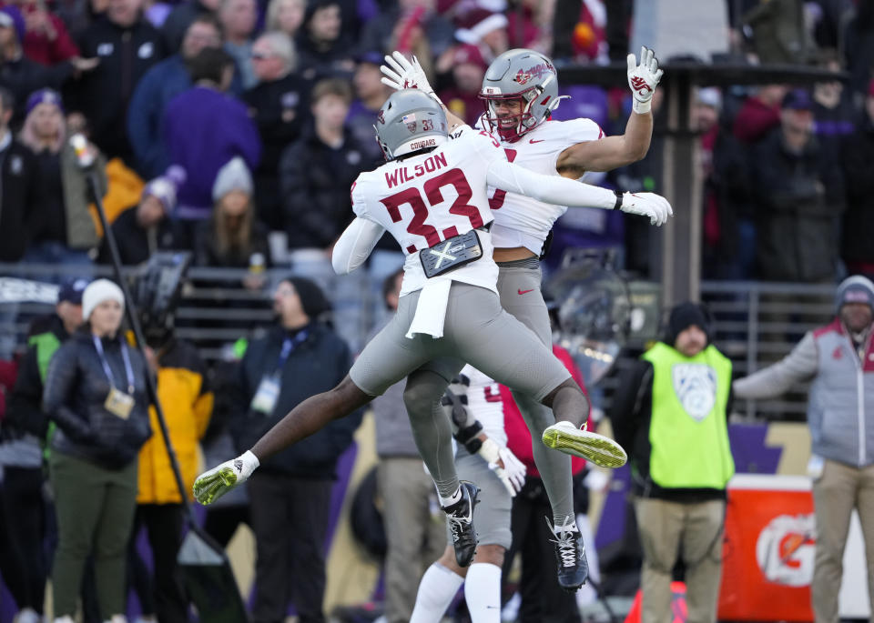 Washington State defensive back Sam Lockett III, facing, jumps up to celebrate a missed field goal attempt by Washington with teammate Adrian Wilson (33) during the first half of an NCAA college football game, Saturday, Nov. 25, 2023, in Seattle. (AP Photo/Lindsey Wasson)