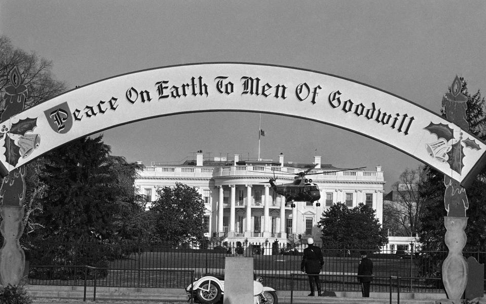 A banner reading "Peace on earth to men of goodwill" hangs outside the White House in 1963.