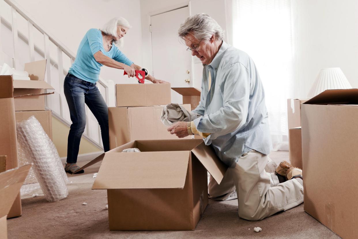 senior couple packing boxes for moving in home