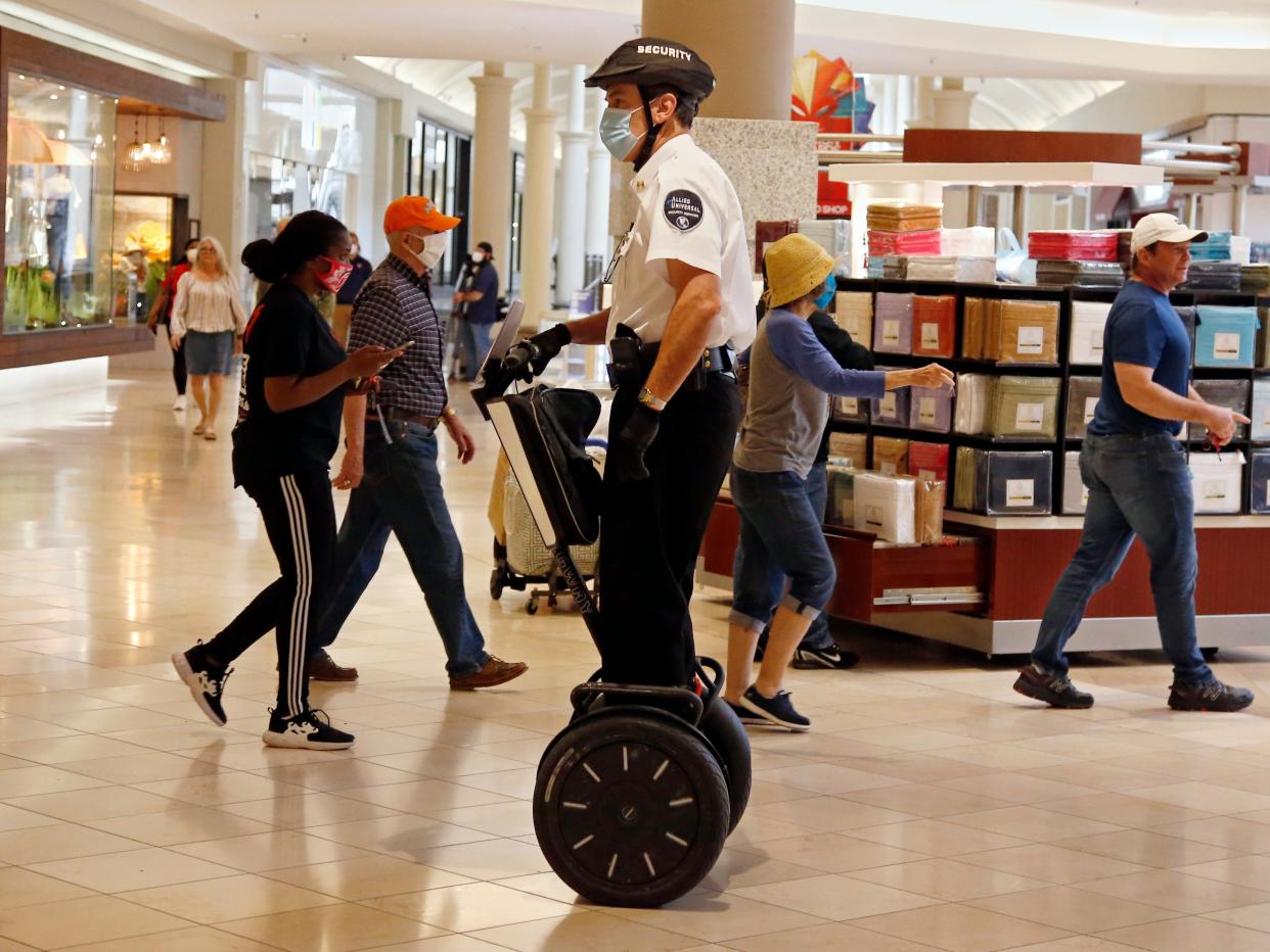 FILE - In this May 1, 2020 file photo, a security guard wearing a mask and riding a Segway patrols inside Penn Square Mall as the mall reopens in Oklahoma City.  Segway says it will end production of its namesake two-wheeled balancing personal transporter, popular with tourists and police officers but perhaps best known for its high-profile crashes. The company, founded in 1999 by inventor Dean Kamen, will retire the Segway PT on July 15.  (AP Photo/Sue Ogrocki, File