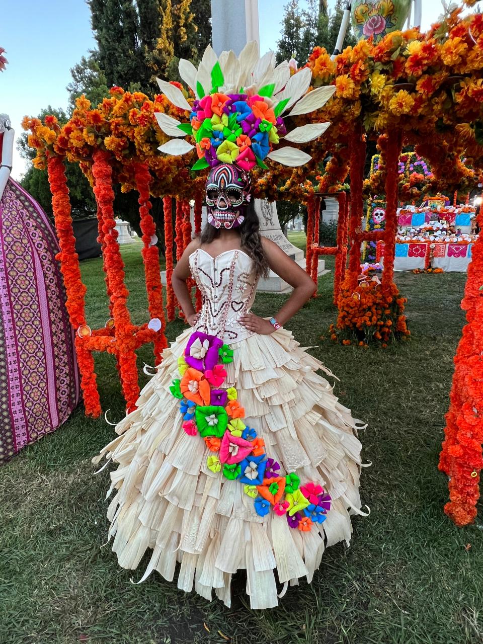 Daniela Rico, a 17-year-old from Riverside, California, poses in front of an altar during the Día de Los Muertos celebration at the Hollywood Forever Cemetery in Los Angeles on Saturday, Oct. 28, 2023.