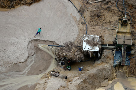 A miner runs away from an illegal cassiterite mine during an operation conducted by agents of the Brazilian Institute for the Environment and Renewable Natural Resources, or Ibama, in national parks near Novo Progresso, southeast of Para state, Brazil, November 4, 2018. REUTERS/Ricardo Moraes