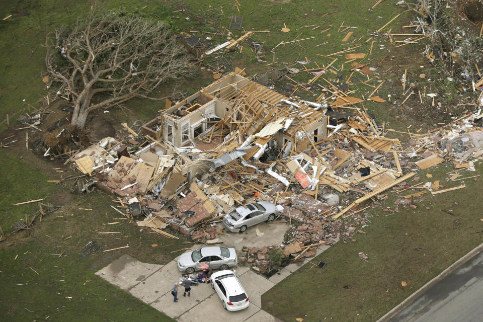 Two men stand in front of a destroyed house in Mayflower, Ark., Monday, April 28, 2014, after a tornado struck the town late Sunday. A tornado system ripped through several states in the central U.S. and left at least 17 dead in a violent start to this year's storm season, officials said. (AP Photo/Danny Johnston)