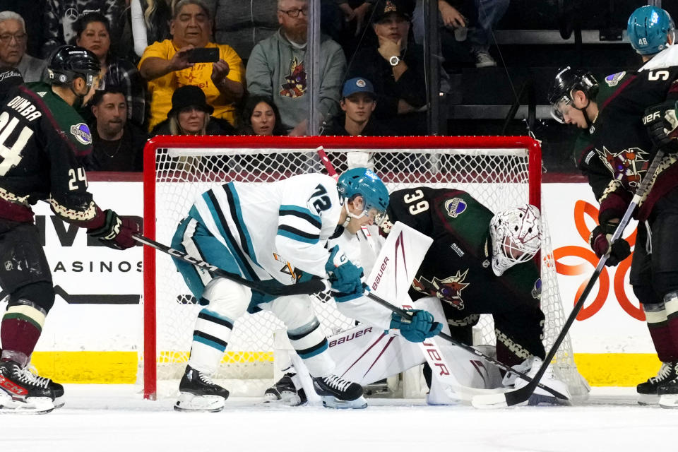 Arizona Coyotes goaltender Connor Ingram (39) makes a save on a shot by San Jose Sharks left wing William Eklund (72) as Coyotes defensemen Matt Dumba (24) and Troy Stecher, right, watch during the first period of an NHL hockey game Friday, Dec. 15, 2023, in Tempe, Ariz. (AP Photo/Ross D. Franklin)