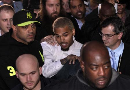 Rapper Chris Brown (C) leaves the U.S. District Court in Washington October 28, 2013. Rapper Chris Brown was due in court to face a felony assault charge stemming from a fight outside hotel, the latest legal run-in for the Grammy-winning singer. REUTERS/Yuri Gripas