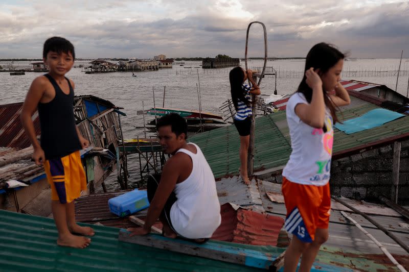 The Wider Image: Rising seas threaten early end for sinking village in Philippines