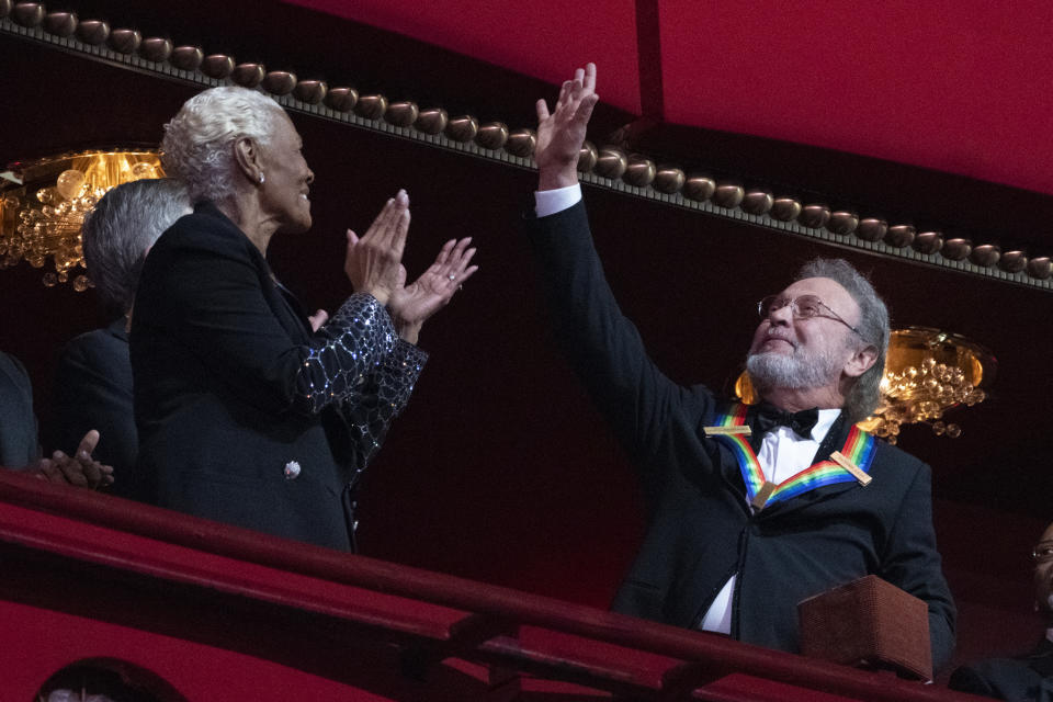 2023 Kennedy Center Honoree Billy Crystal waves as he is applauded by fellow honoree Dionne Warwick at the 46th Kennedy Center Honors at the John F. Kennedy Center for the Performing Arts in Washington, Sunday, Dec. 3, 2023. (AP Photo/Manuel Balce Ceneta)