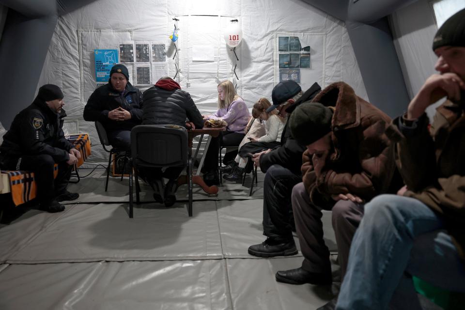 Citizens keep warm in an invincibility tent on December 07, 2022 in Borodyanka, Ukraine.