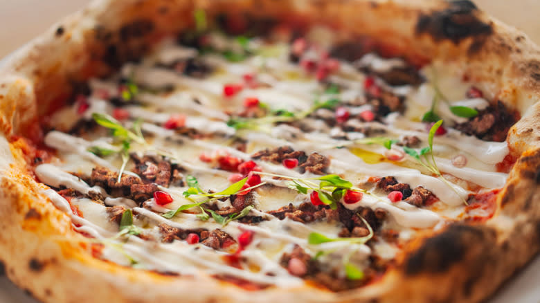 Homemade pizza with cricket mince yogurt and pomegranates