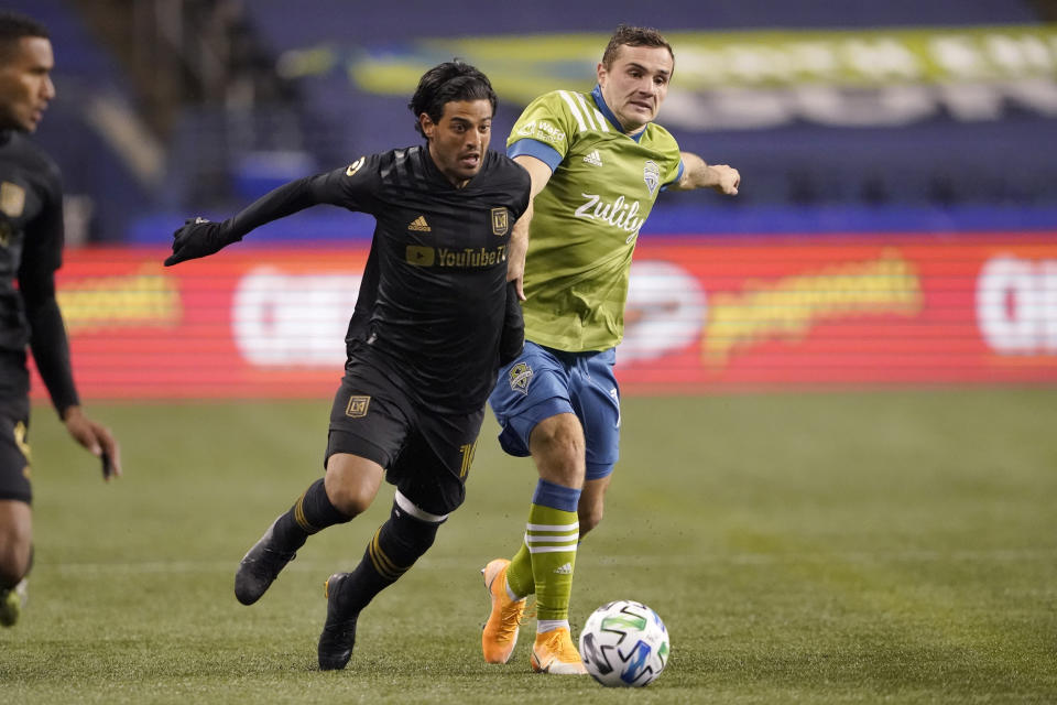 FILE - Los Angeles FC forward Carlos Vela and Seattle Sounders forward Jordan Morris, right, vie for the ball during the second half of an MLS playoff soccer match in Seattle, in this Tuesday, Nov. 24, 2020, file photo. Vela, who had an MLS record 34 goals in 2019, missed the MLS is Back tournament because of his wife's pregnancy and the birth of their child. Then he was hampered by injuries, appearing in only eight games. (AP Photo/Ted S. Warren, File)