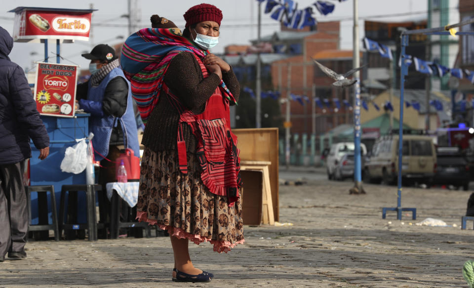 Una mujer carga a su hijo en El Alto, Bolivia, el viernes 16 de octubre de 2020. (AP Foto/Juan Karita)