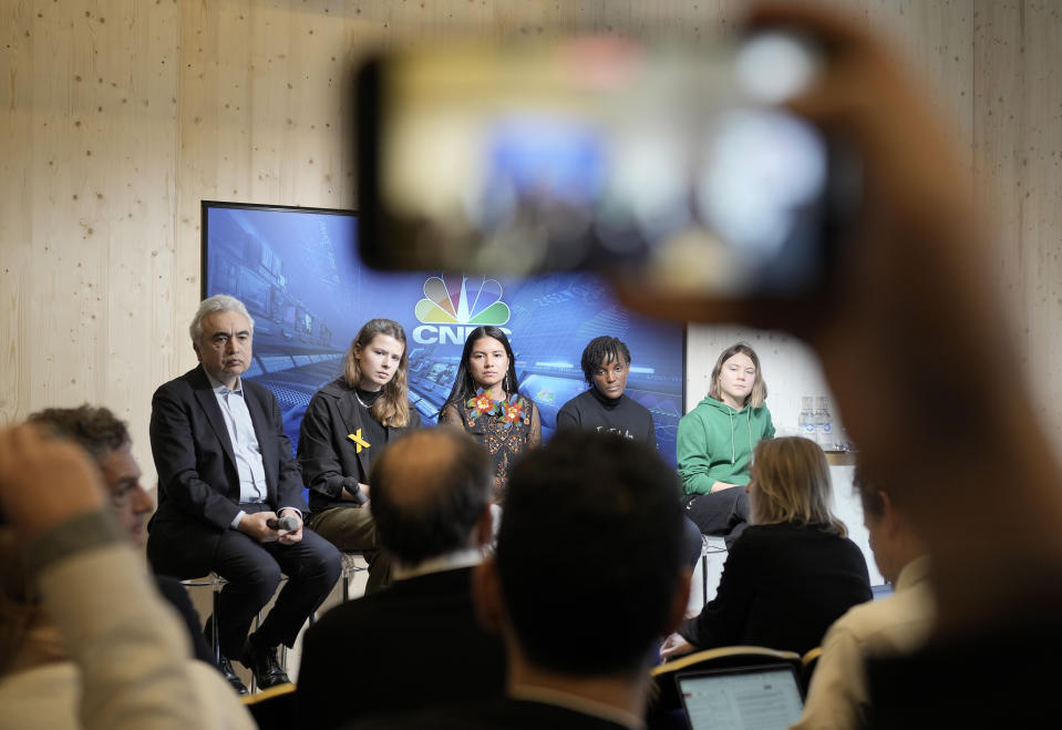 People making photos with their phones of climate activists Greta Thunberg of Sweden, Vanessa Nakate of Uganda, Helena Gualinga of Ecuador, Luisa Neubauer of Germany, and Fatih Birol, Head of the International Energy Agency, from right, at a press conference at the World Economic Forum in Davos, Switzerland Thursday, Jan. 19, 2023. The annual meeting of the World Economic Forum is taking place in Davos from Jan. 16 until Jan. 20, 2023. (AP Photo/Markus Schreiber)