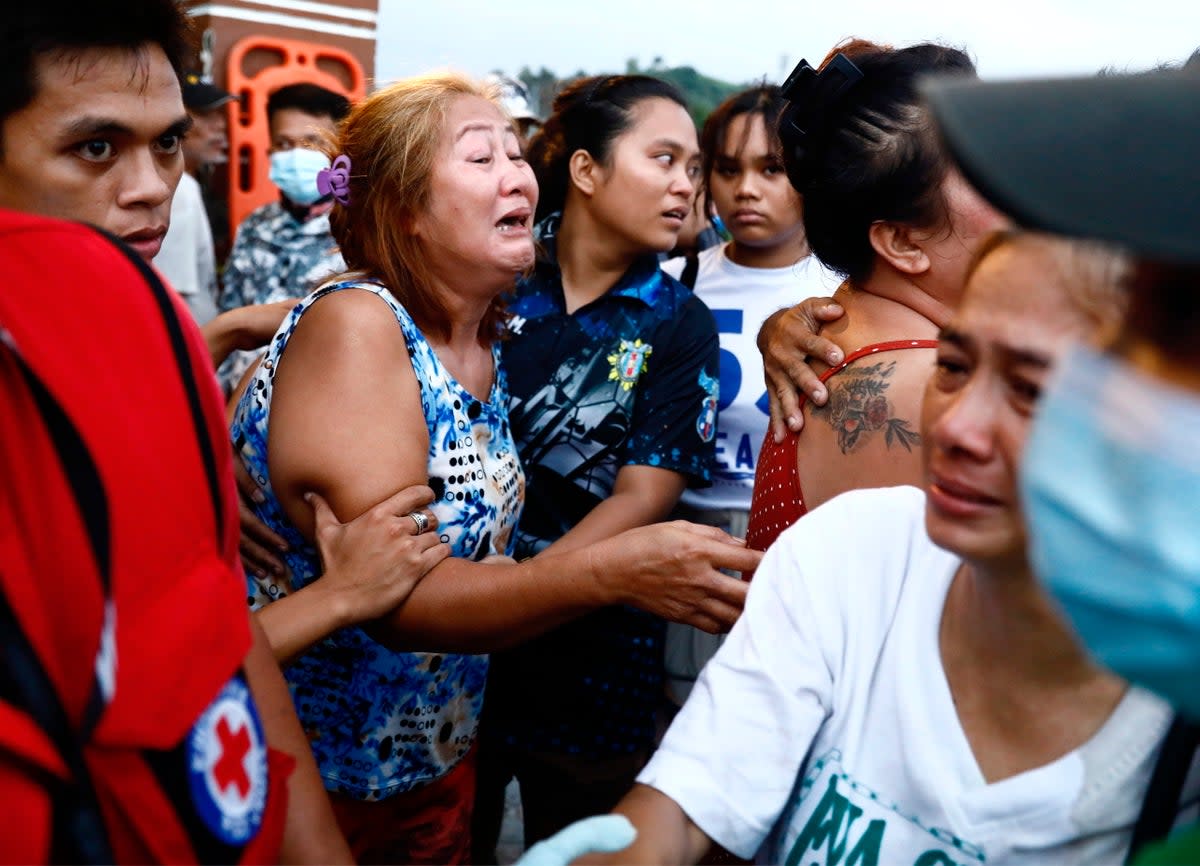 Relatives of a victim of typhoon react at the Binangonan port, Rizal province (EPA)