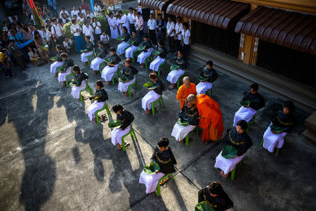 Thai women devotees have their hair cut by Dhammananda Bhikkhun and a female buddhist monk during a mass female Buddhist novice monk ordination ceremony at the Songdhammakalyani monastery, Nakhon Pathom province, Thailand, December 5, 2018. REUTERS/Athit Perawongmetha