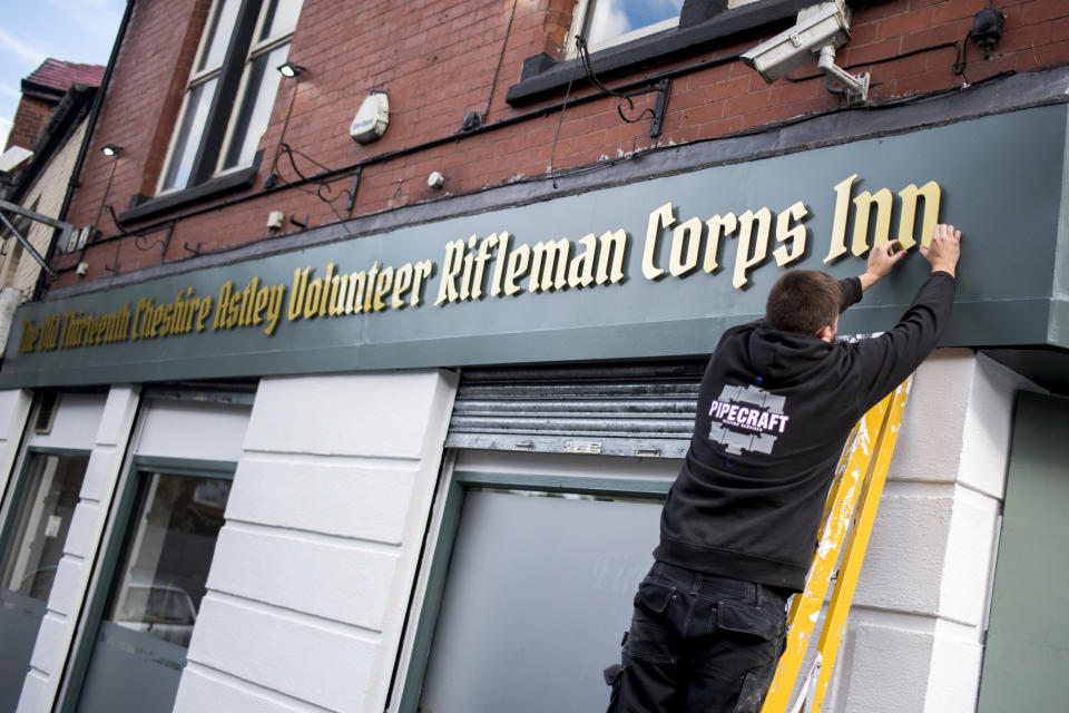 STALYBRIDGE, ENGLAND - MAY 31: A workman finishes the lettering on the sign of The Old Thirteenth Cheshire Astley Volunteer Rifleman Corps Inn, the pub with the longest name in the world on May 31, 2019 in Stalybridge, England. The pub which reopens tomorrow was awarded a Guinness World Record in 1995 and has now reopened close to the Q Inn, the pub with the shortest name in the world. (Photo by Anthony Devlin/Getty Images)