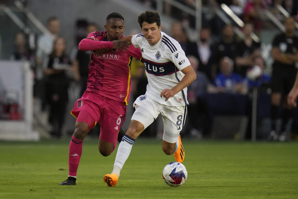 Vancouver Whitecaps' Alessandro Schopf (8) brings the ball down the pitch as St. Louis City's Njabulo Blom (6) defends during the first half of an MLS soccer match Saturday, May 27, 2023, in St. Louis. (AP Photo/Jeff Roberson)