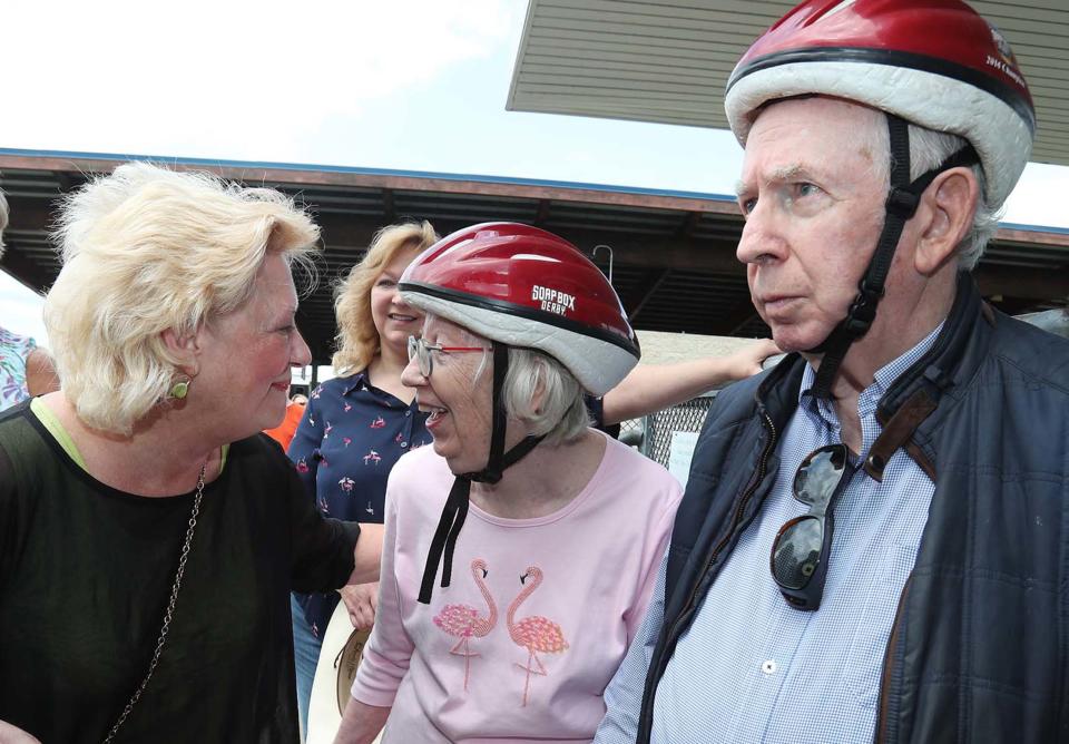 Nancy Eichenlaub Ferruccio, left, and Julie Callahan share a laugh as the women and Julie's husband Kennon Callahan wait their turn to ride down the hill at Derby Downs during Senior Day on Thursday in Akron.