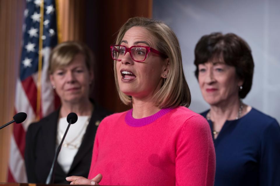 Sen. Kyrsten Sinema, D-Ariz., flanked by Sen. Tammy Baldwin, D-Wis., left, and Sen. Susan Collins, R-Maine, speaks to reporters following Senate passage of the Respect for Marriage Act, at the Capitol in Washington, Tuesday, Nov. 29, 2022.