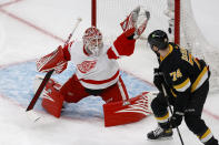 Detroit Red Wings goaltender Magnus Hellberg (45) makes a glove save as Boston Bruins left wing Jake DeBrusk (74) looks on during the first period of an NHL hockey game, Saturday, March 11, 2023, in Boston. (AP Photo/Mary Schwalm)