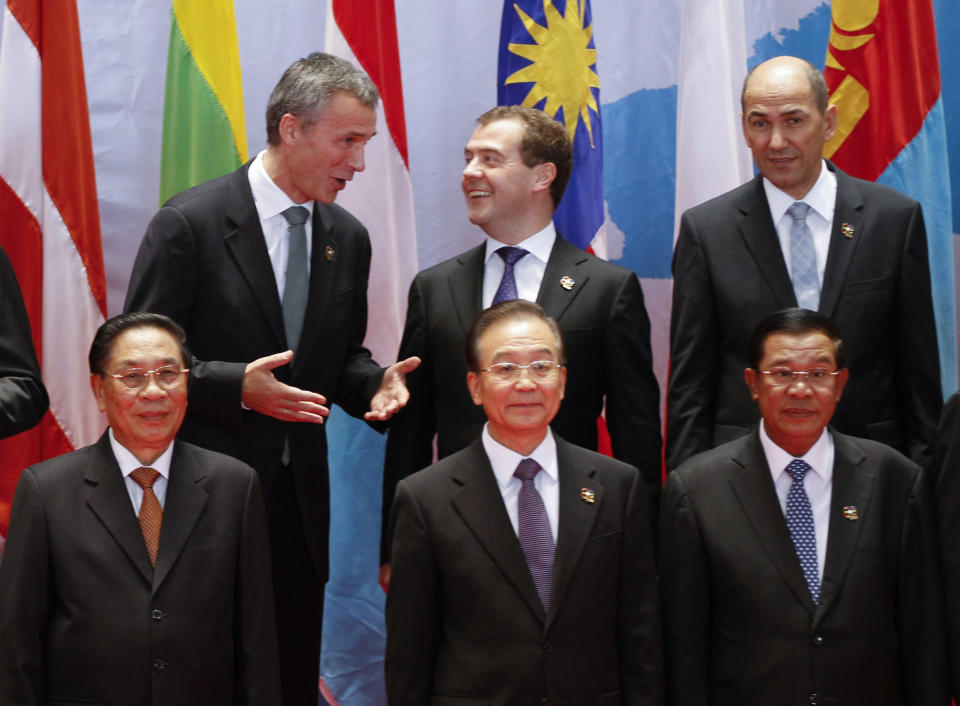 Russian Prime Minister Dmitry Medvedev, top center, listens to his Norwegian counterpart Jens Stoltenberg, top left, as Laotian President Choummaly Sayasone, bottom left, Chinese Premier Wen Jiabao, bottom center, Cambodian Prime Minister Hun Sen, bottom right, and Slovenian Prime Minster Janez Jansa join them for a family photo before the opening ceremony for the ASEM Summit in Vientiane, Laos, Monday, Nov. 5, 2012. (AP Photo/Vincent Thian)