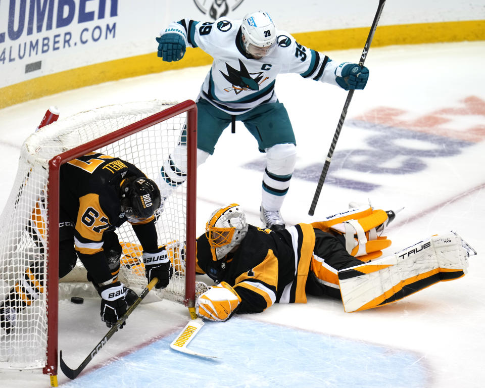 San Jose Sharks' Logan Couture (39) celebrates his goal against Pittsburgh Penguins goaltender Casey DeSmith (1) with Rickard Rakell (67) defending during the third period of an NHL hockey game in Pittsburgh, Saturday, Jan. 28, 2023. The Sharks won 6-4. (AP Photo/Gene J. Puskar)