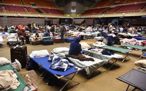 Refugees are seen at the Roberto Clemente Coliseum refuge in San Juan, Puerto Rico - Credit: HECTOR RETAMAL/AFP