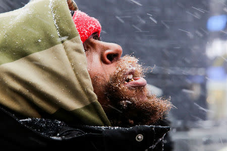 A man looks at falling snow at Times Square as a cold weather front hits the region, in Manhattan, New York, U.S., December 30, 2017. REUTERS/Eduardo Munoz