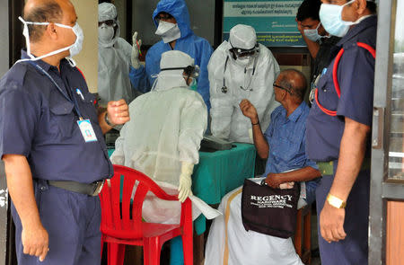 Medics wearing protective gear examine a patient at a hospital in Kozhikode in the southern state of Kerala, India May 21, 2018. Picture taken May 21, 2018. REUTERS/Stringer