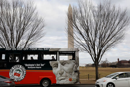 A tour bus passes the Washington Monument in Washington, U.S., on the second day of Government shutdown, January 21, 2018. REUTERS/Yuri Gripas