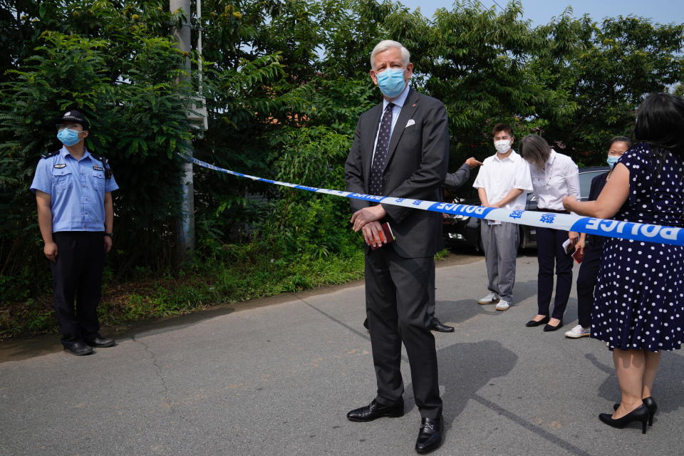 Dominic Barton, Ambassador of Canada to China stands near a barricade tape as he arrives at a detention center to meet Canadian Michael Spavor, in Dandong, China, Wednesday, Aug. 11, 2021. A Chinese court has sentenced Spavor to 11 years on spying charges in case linked to Huawei. (AP Photo/Ng Han Guan)