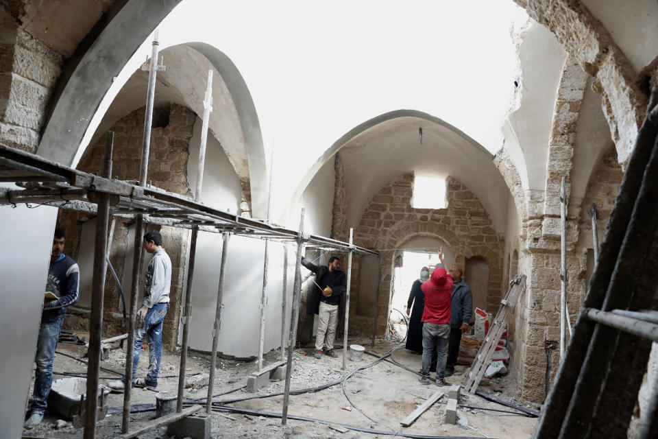 Architects and workers renovate the long-abandoned 200-year-old Ghussein palace, in the old quarter of Gaza City, Monday, Dec. 14, 2020. Less than 200 of these old houses are still partly or entirely standing, according to officials and they are threatened by neglect, decaying and urban sprawl. (AP Photo/Adel Hana)