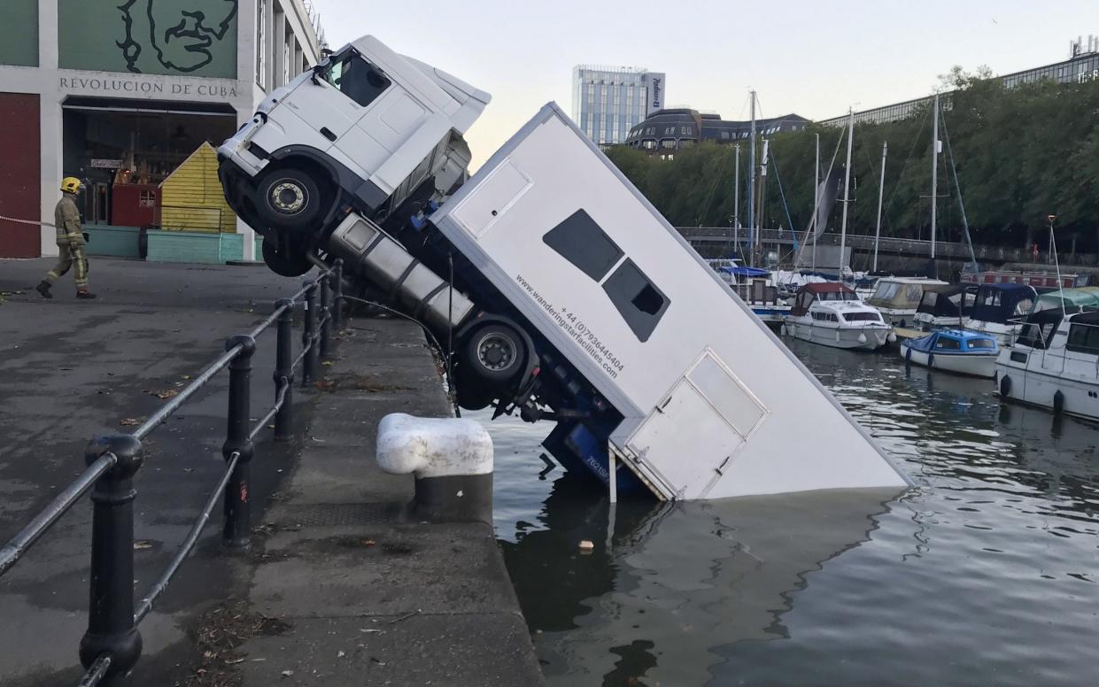 The lorry is seen half submerged in Bristol Harbourside, - SWNS