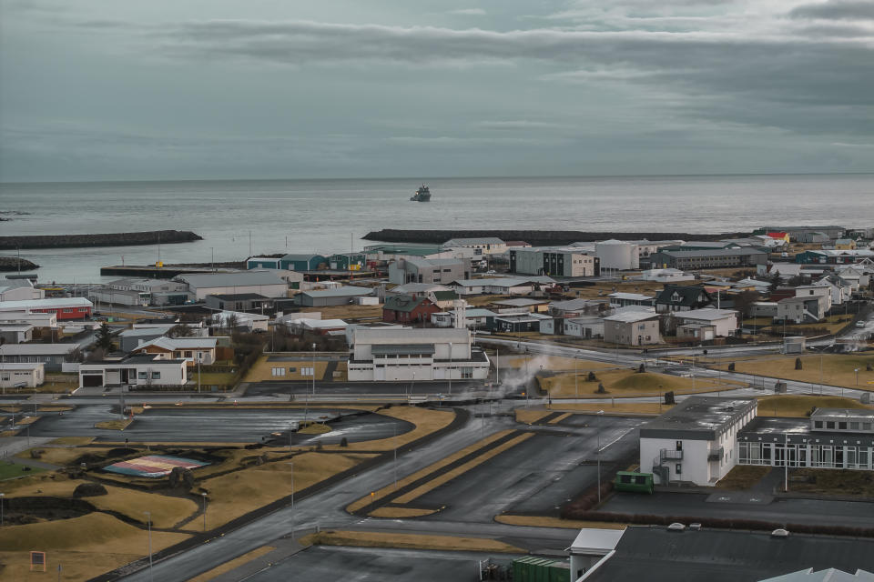 This image taken with a drone shows the town of Grindavik, Iceland, as a Coast Guard vessel patrol, Thursday, Nov. 16, 2023. Residents of a fishing town in southwestern Iceland have left their homes after increasing concern about a potential volcanic eruption caused civil defense authorities to declare a state of emergency in the region. Iceland's Meteorological Office says police decided to evacuate Grindavik after recent seismic activity in the area moved south toward the town. (AP Photo/Bjorn Steinbekk)