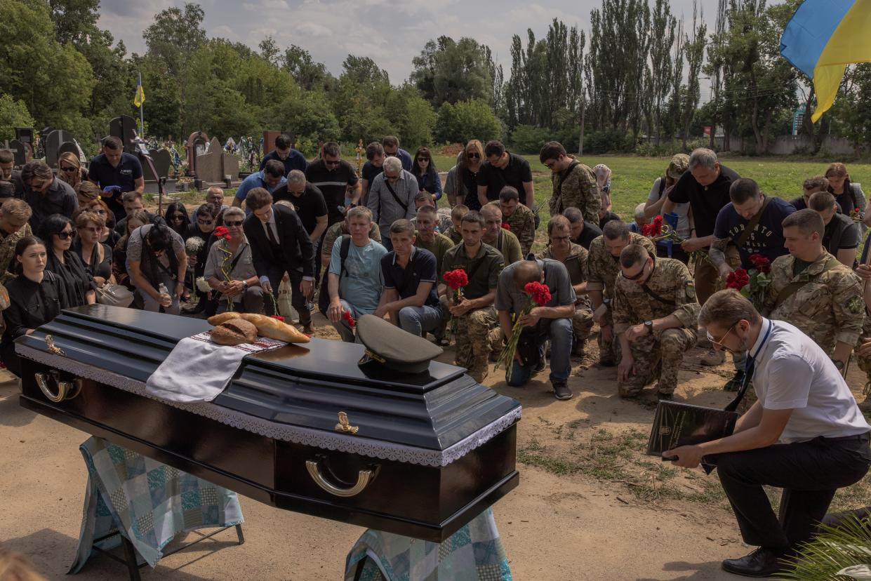 Relatives and friends kneel down next to the coffin of Anton Klitnyi, a Ukrainian serviceman, who was killed fighting Russian troops in the Zaporizhzhia region (Getty Images)