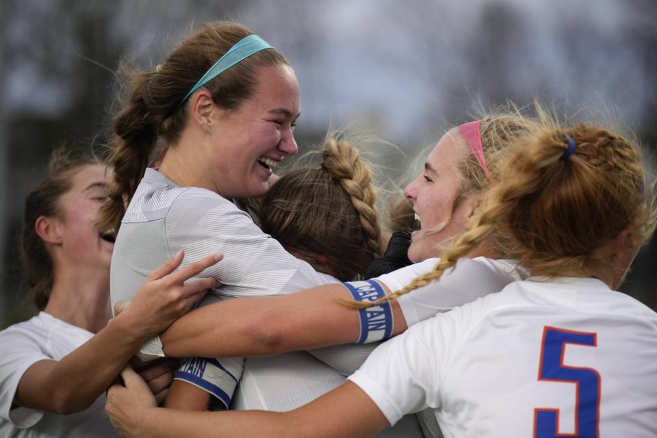 Olentangy Orange’s Kaelyn Valleau (center right) celebrates with Jadia Kershaw (center left) and the rest of the Pioneers after defeating Dublin Jerome 1-0 in a Division I regional final Nov. 5 at Marysville.