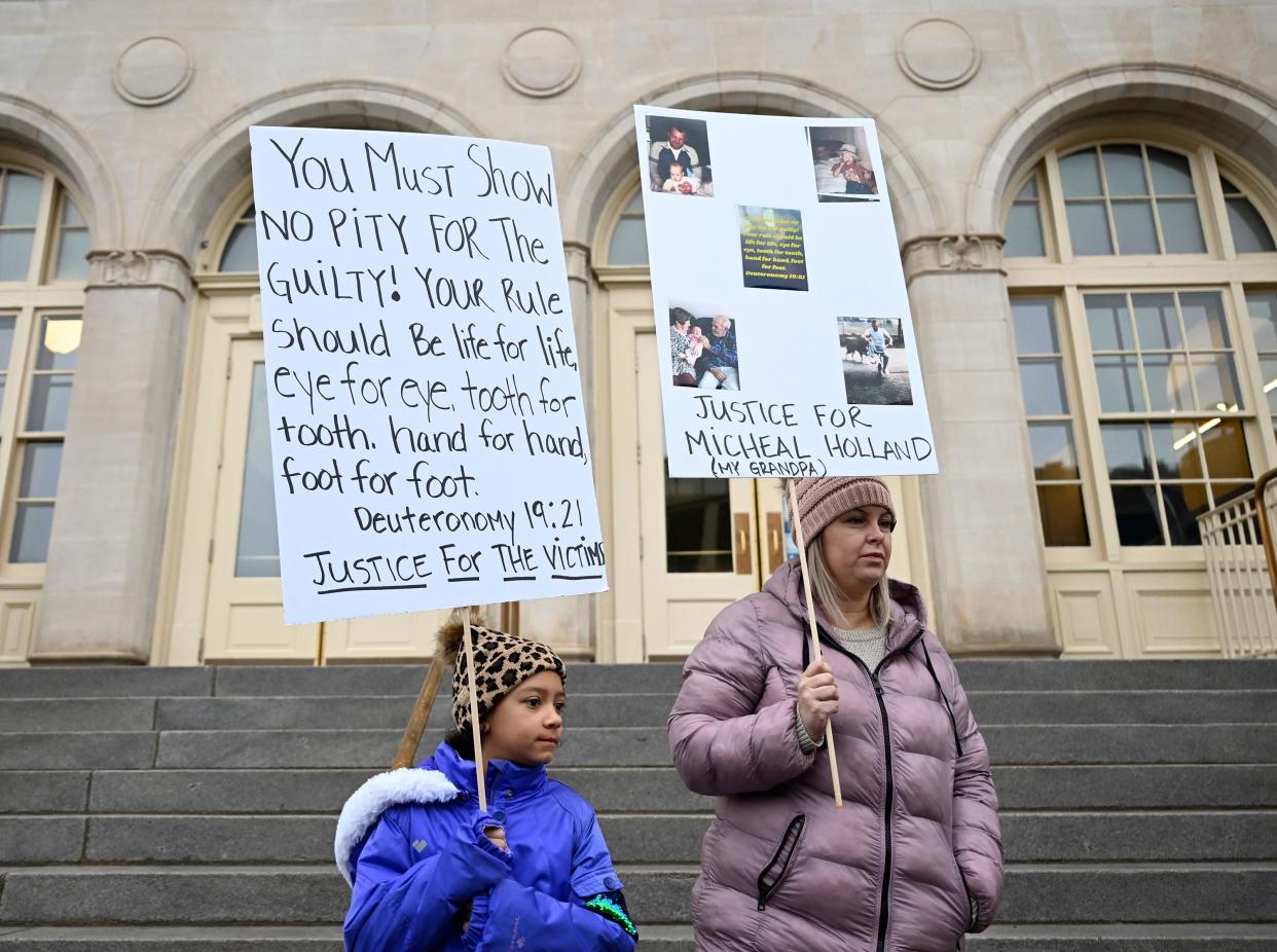 Nine-year-old Lyric Jones and her mother Teran Christian stands outside Wayne Aspinall Courthouse on Tuesday, Jan.  3, 2023 in Grand Junction, Colo. The two came to the courthouse for the sentencing of Megan Hess and Shirley Koch. Christian's grandfather Michael Holland was a victim along with hundreds of other families who used Sunset Mesa Funeral home. (RJ Sangosti/The Denver Post via AP)