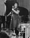 <p>Ella Fitzgerald performing in an all-black duchess satin dress with platform patent-leather Mary Janes.</p>