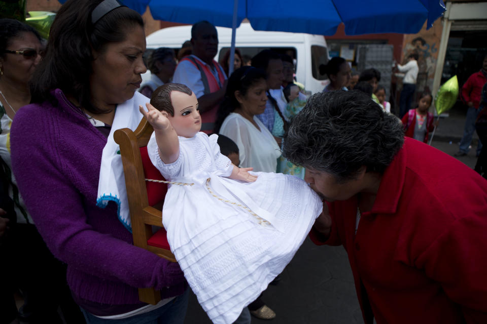 A woman kisses the costume of one of several dolls representing the Baby Jesus, during during a festival celebrating a 400-year-old representation of the Baby Jesus, in Xochimilco, on the southern edge of Mexico City, Wednesday, May 7, 2014. In Xochimilco, busy markets stand side by side with colonial churches, and children ride to school in boats pushed by poles, along a network of canals and floating gardens that date to pre-hispanic times. The popular tourist destination was declared a UNESCO world heritage site in 1987. (AP Photo/Rebecca Blackwell)