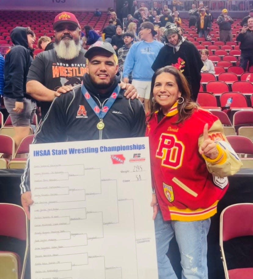 Daniel Herrera celebrates a state wrestling title in Iowa with his parents.