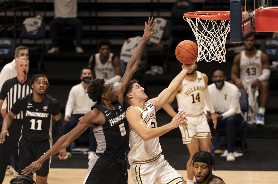 Villanova's Collin Gillespie, right, goes up for the shot against Providence's Jimmy Nichols Jr., left, during the second half of an NCAA college basketball game Saturday, Jan. 23, 2021, in Villanova, Pa. Villanova won 71-56. (AP Photo/Chris Szagola)