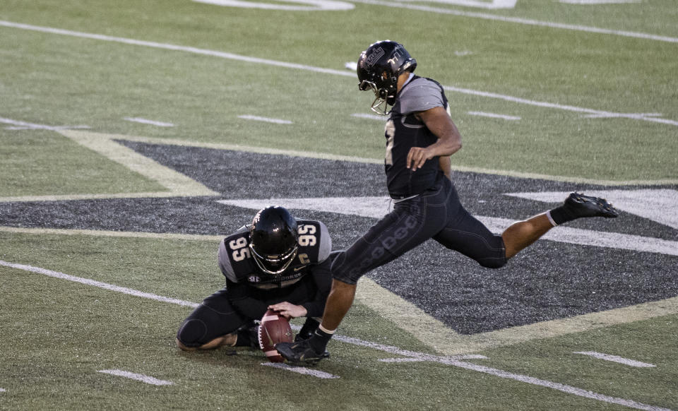 CORRECTS ID TO PIERSON COOKE NOT, SARAH FULLER, AND FIELD GOAL ATTEMPT, NOT AN EXTRA POINT - Vanderbilt kicker Pierson Cooke attempts field goal as Harrison Smith (95) holds during the second half of an NCAA college football game against Tennessee, Saturday, Dec. 12, 2020, in Nashville, Tenn. (AP Photo/Wade Payne)