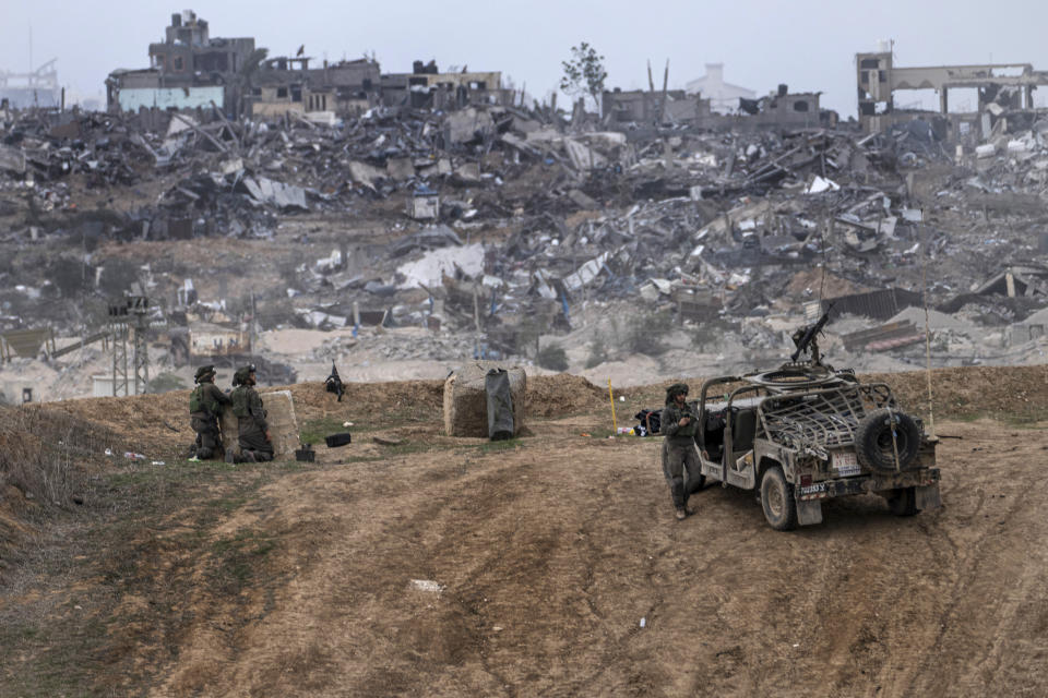 Israeli army vehicles and soldiers are seen near the Gaza Strip border, in southern Israel, Saturday, Dec. 23, 2023. The army is battling Palestinian militants across Gaza in the war ignited by Hamas' Oct. 7 attack into Israel. (AP Photo/Tsafrir Abayov)