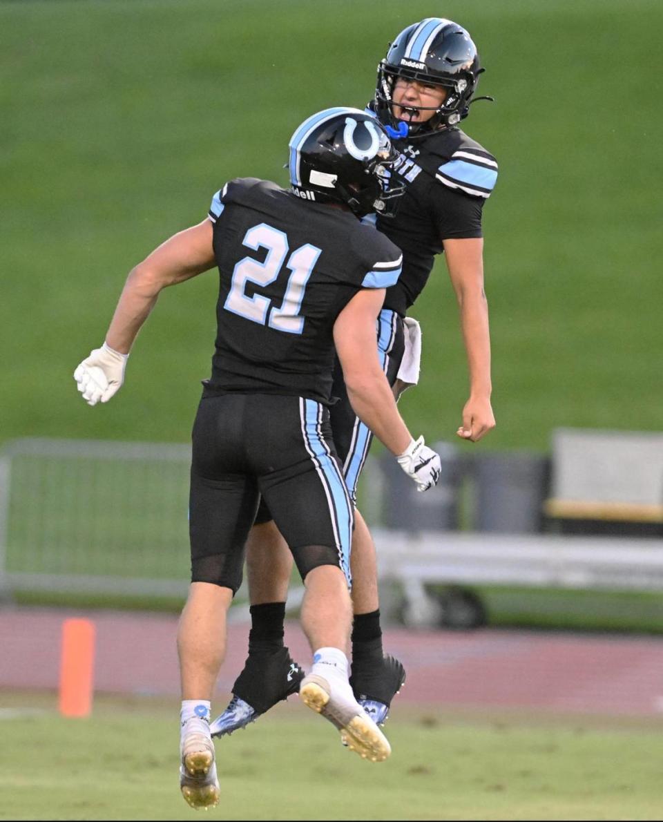 Clovis North’s Jackson Cinfel, left, celebrates a touchdown run with quarterback Mario Cosma during their game against Memorial at Veterans Memorial Stadium in Clovis on Friday, Aug. 18, 2023.