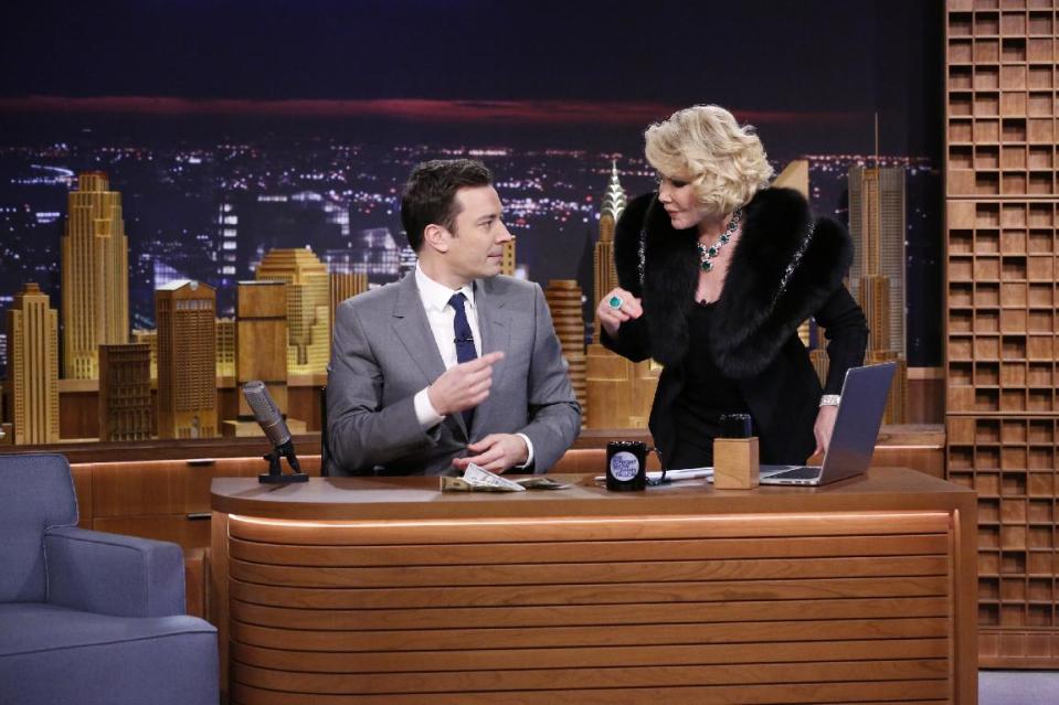 In this photo provided by NBC, Jimmy Fallon appears with Joan Rivers, right, during his "The Tonight Show" debut on Monday, Feb. 17, 2014, in New York. Fallon departed from the network's “Late Night” on Feb. 7, 2014, after five years as host, and is now the host of “The Tonight Show.” Rivers appeared on the show after 49 years earlier to the day, the veteran comedian had made her first appearance on "The Tonight Show Starring Johnny Carson" in that very studio, and had not appeared on "Tonight" since 1987, when she was banned by Carson after jumping to Fox to host her own short-lived show. (AP Photo/NBC, Lloyd Bishop)