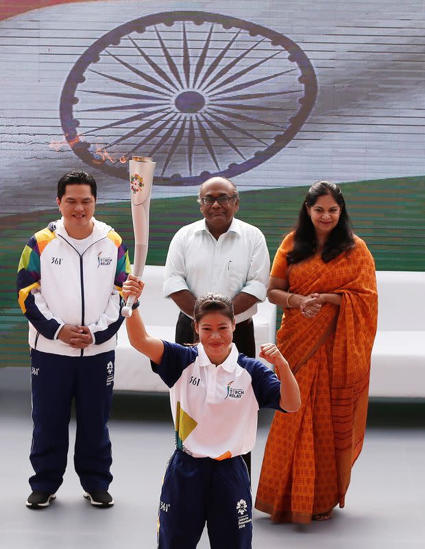 Indian boxer MC Mary Kom gestures as she takes part in the 2018 Asian Games torch relay in New Delhi